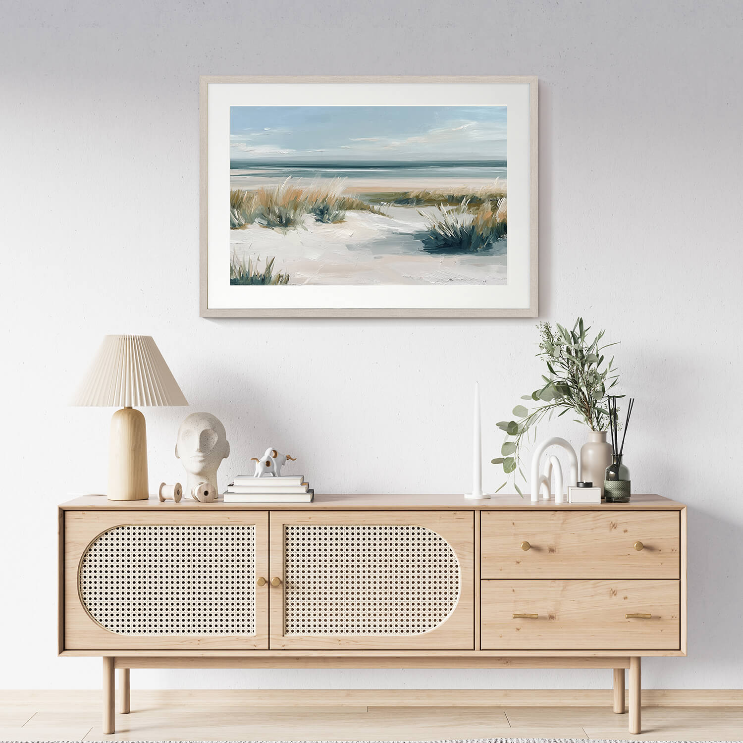 The coastal breezes framed art print hangs above the wooden sideboard.