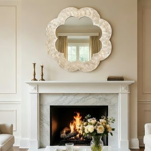 Organic sculptural flower-shaped mirror above the fireplace in the living room.